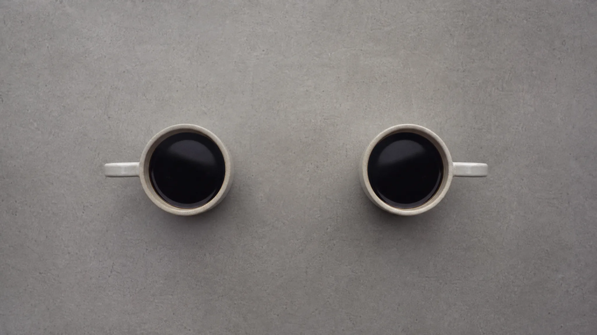 Two identical coffee cups side by side, shot from above