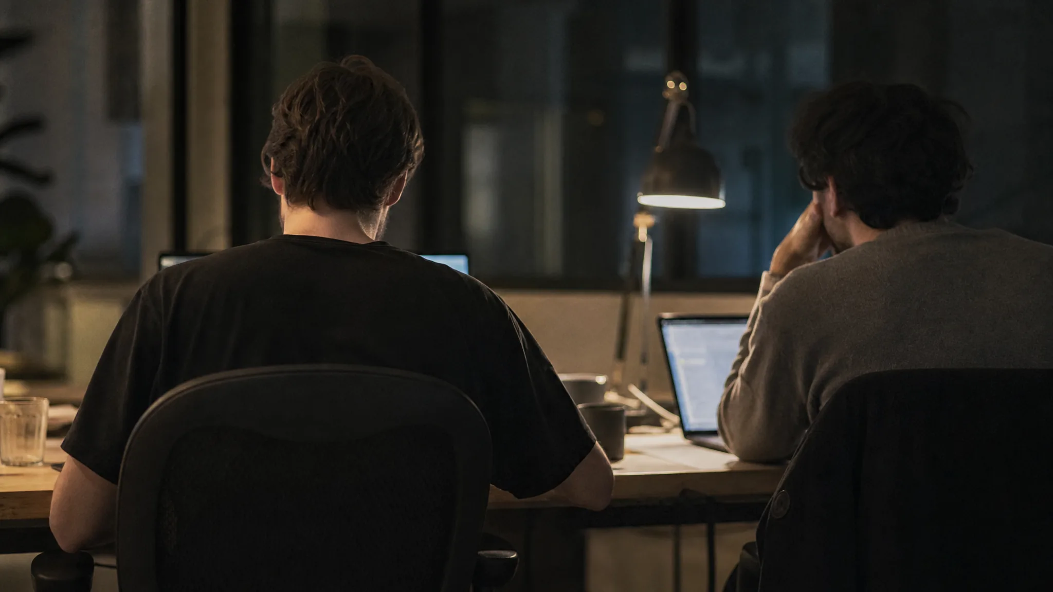 Two founders working late at a shared desk